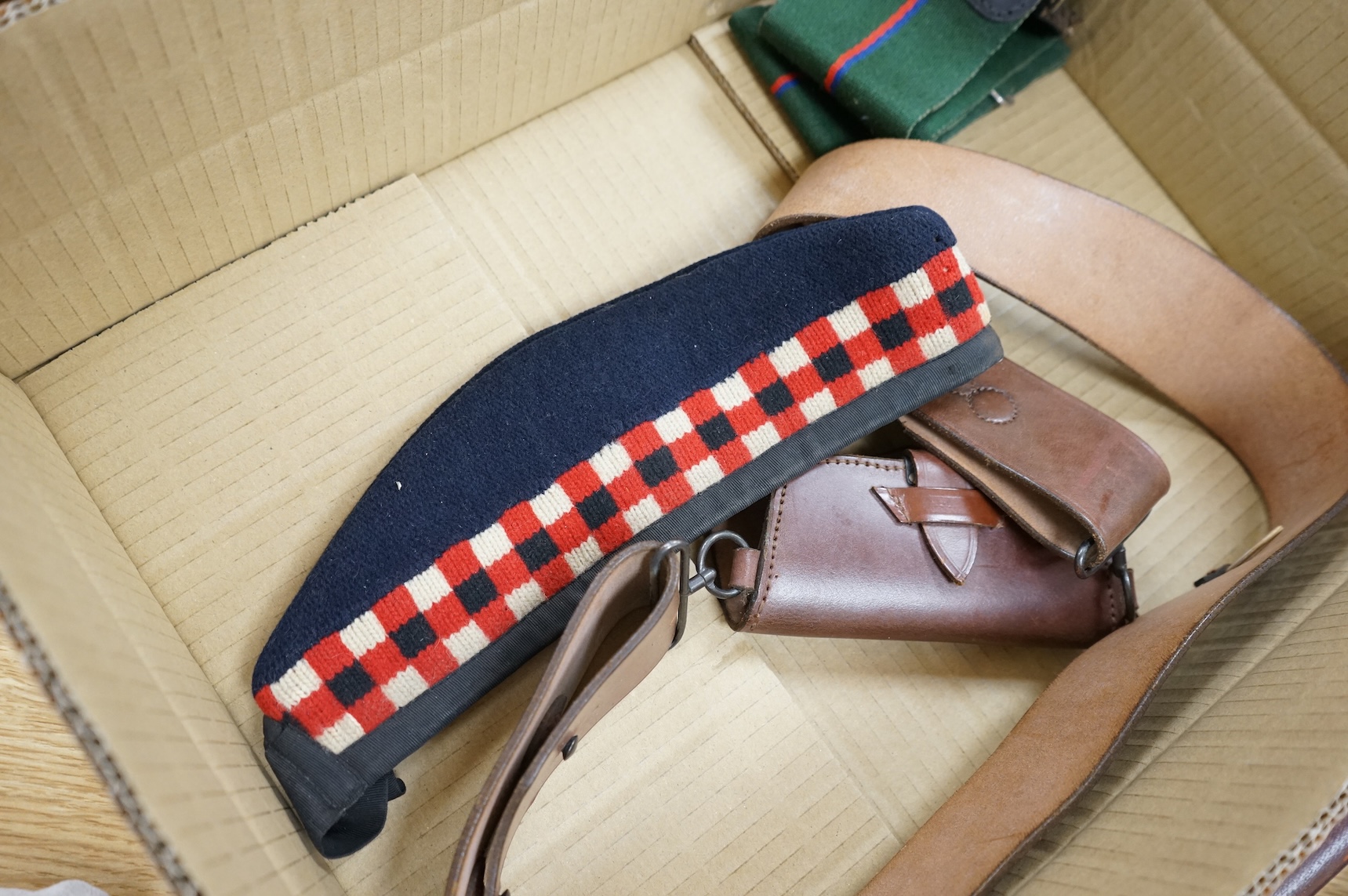 A 1907 bayonet in its scabbard with the tip of the blade shortened, together with a Glengarry cap of the KOSB, post 1902 badge and a brown leather shoulder belt and pouch with QE2 bronze badge of the Royal Artillery